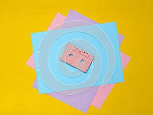 Audio cassette on a pastel-colored paper background. Retro media technology 80s. Music, entertainment. Top view. minimalism trend.