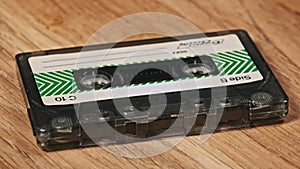 Audio Cassette Rotates on a Wooden Surface Close-Up