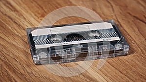 Audio Cassette Rotates on a Wooden Surface Close-Up