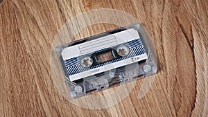 Audio Cassette Rotates on a Wooden Surface Close-Up
