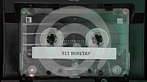 Audio Cassette Tape With 911 Call Wiretap Recording Playing in Deck Player Close