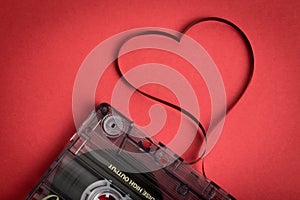 Audio cassette tape on red backgound. Film shaping heart