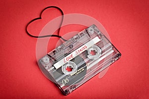 Audio cassette tape on red backgound. Film shaping heart
