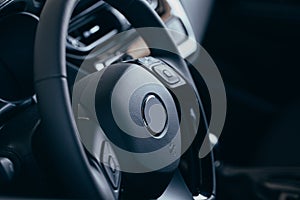 Audio control buttons on the steering wheel of a modern car