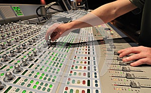 Audio engineer operating mixing console