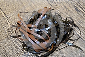 Audio film on the table. A magnetic film pulled out of a broken cassette.