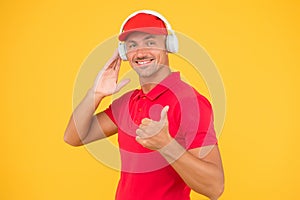 Audio guide. Man in headphones on yellow background. Assistant call center help find solution. Guy call service worker