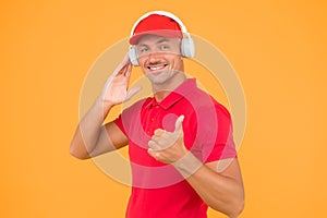 Audio guide. Man in headphones on yellow background. Assistant call center help find solution. Guy call service worker