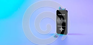Audio guide online app on digital mobile smartphone screen with music headphones on neon background. Devices for