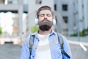 Audio meditation. Bearded man listen to music with closed eyes. Hipster wear audio headphones outdoors. Relaxing audio