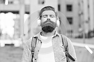 Audio meditation. Bearded man listen to music with closed eyes. Hipster wear audio headphones outdoors. Relaxing audio