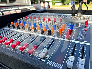 audio mixer soundboard. The mixing console features several rows