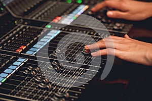 Audio system for professionals. Close-up view of sound engineer adjusting digital audio mixing console. Sound recording