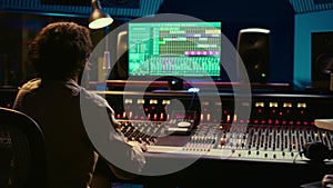 Audio technician uses mixing and mastering techniques in studio
