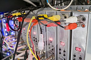 Audio and video wires are connected to TV receivers in the server room of the data center. Modulators of a television signa are