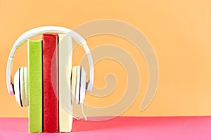 Audio vs. paper book concept. Reading versus listening. Books and headphones on table