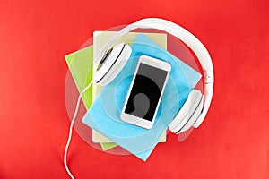 Audio vs. paper book concept. Reading versus listening. Books and headphones on table