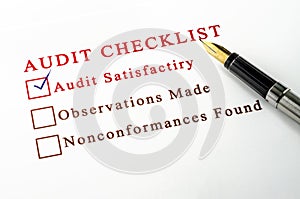 Audit checklist, with tick against on white paper.
