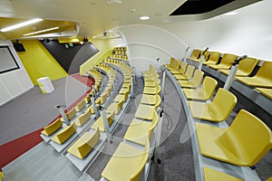 Auditorium with chairs and microphones, stand for photo