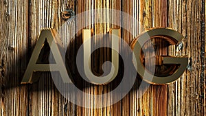 AUG brass write on raw wooden background - 3D rendering