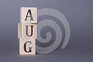 AUG text made of wooden cube on gray background