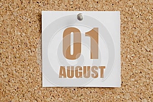 august 01. 01th day of the month, calendar date.White calendar sheet attached to brown cork board.Summer month, day of