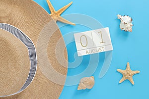 August 01. Wooden calendar on a blue background with summer accessories, top view