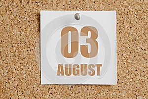 august 03. 03th day of the month, calendar date.White calendar sheet attached to brown cork board.Summer month, day of