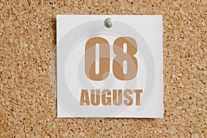 august 08. 08th day of the month, calendar date.White calendar sheet attached to brown cork board.Summer month, day of