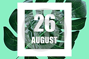 august 26th. Day 26 of month,Date text in white frame against tropical monstera leaf on green background summer month