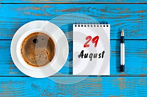 August 29th. Day 29 of month, daily calendar on blue background with morning coffee cup. Summer time. Unique top view