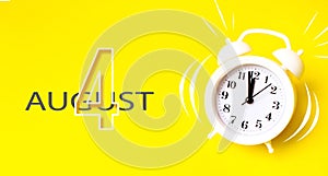 August 4th. Day 4 of month, Calendar date. White alarm clock  with calendar day on yellow background. Minimalistic concept of time