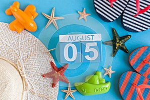 August 5th. Image of August 5 calendar with summer beach accessories and traveler outfit on background. Summer day