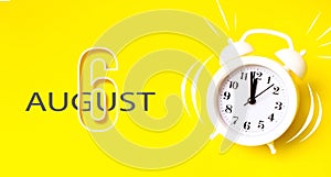 August 6th. Day 6 of month, Calendar date. White alarm clock  with calendar day on yellow background. Minimalistic concept of time
