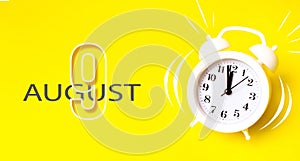 August 9th. Day 9 of month, Calendar date. White alarm clock  with calendar day on yellow background. Minimalistic concept of time