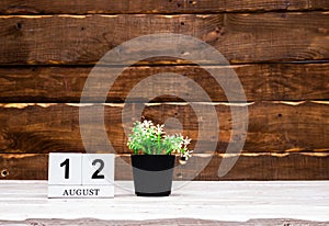 August calendar with number 12. Planner copy space on a wooden brown background. March number icon. Place for text background