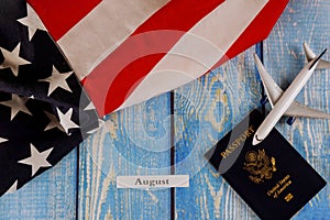 August month of calendar year, travel tourism, emigration the USA American flag with U.S. passport and passenger model plane