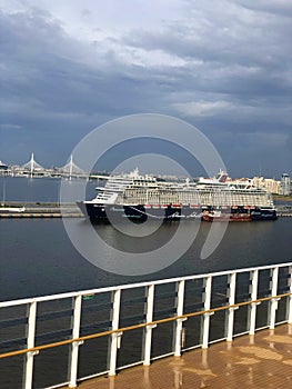 Cruise ship approaching dock. St. Petersburg, Russia. Skyline of city, Krestovsky Stadium, and bridge seen from ship