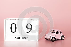 August 09th. Day 9 of month. Calendar cube on modern pink background with car