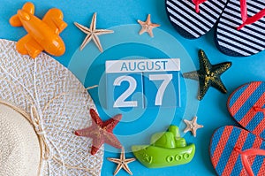August 27th. Image of August 27 calendar with summer beach accessories and traveler outfit on background. Summer day photo