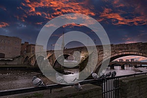 The Auld Brigg Ayr Scotland as the town was covered by a dramatic sunset