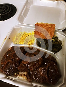 Aunt T's Savoury Oxtails with Brown, Corn, Mustard Greens, an T's Signature Cornbread