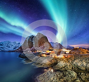 Aurora Borealis above Reine, Lofoten islands, Norway. Nothen light, mountains and houses. Winter landscape at the night time.