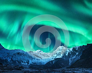 Aurora borealis above snow covered mountain range in europe