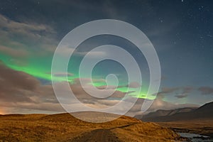Aurora Borealis in Iceland northern lights bright stripe in sky during full moon night