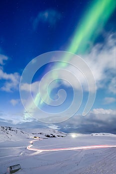 Aurora Borealis in Iceland. Northern Lights over the road. A winter night landscape with bright lights in the sky. Landscape in th