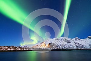 Aurora borealis on the Lofoten islands, Norway. Green northern lights above mountains.