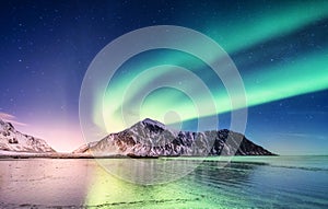 Aurora borealis on the Lofoten islands, Norway. Green northern lights above mountains.