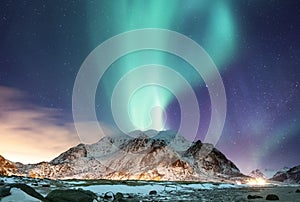 Aurora borealis on the Lofoten islands, Norway. Green northern lights above mountains. Night sky with polar lights. Night winter l