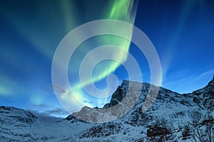 Aurora borealis on the Lofoten islands, Norway. Green northern lights above mountains. Night sky with polar lights. Night winter l